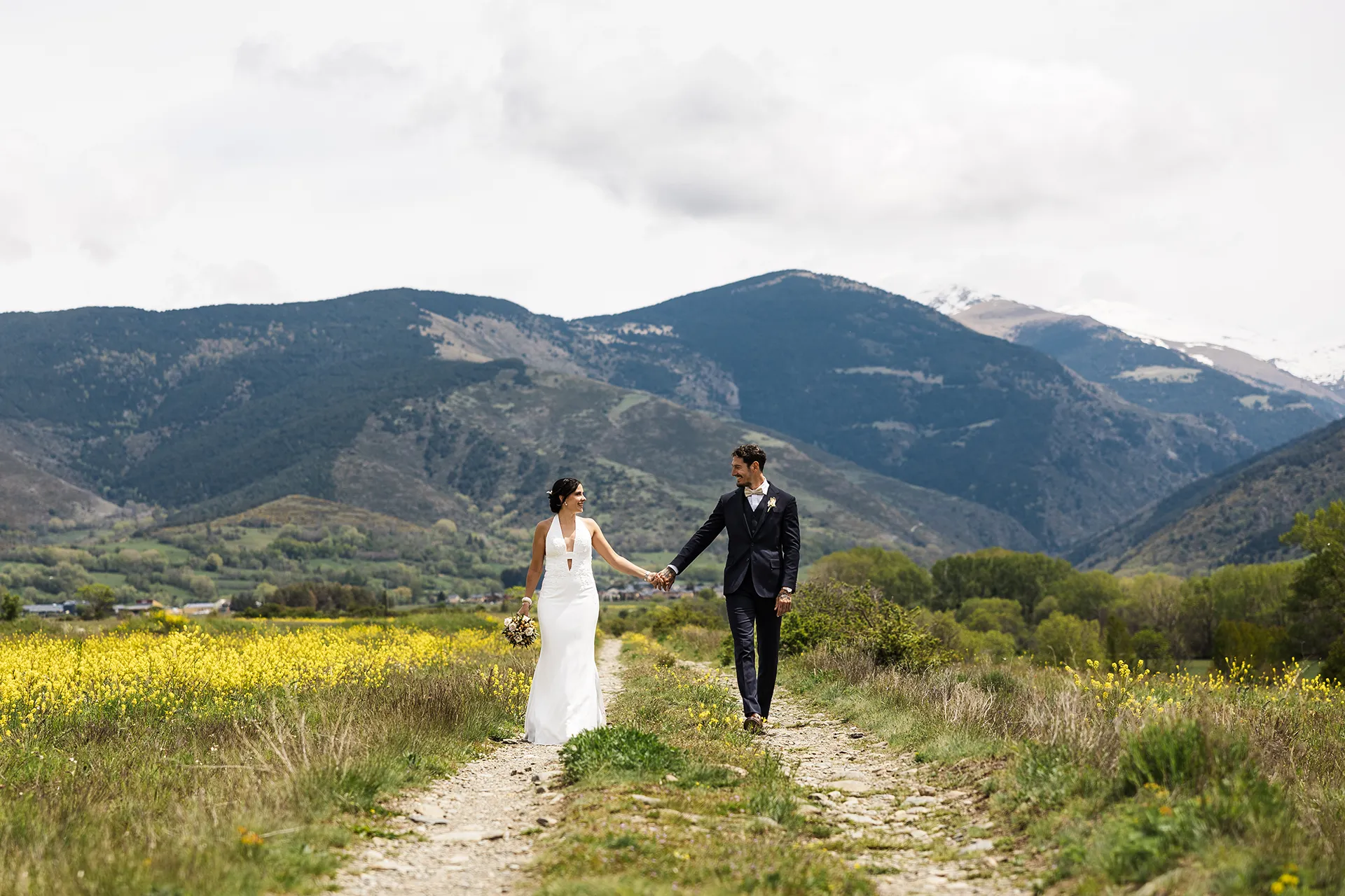 pareja de novios caminando por un camino cogidos de la mano